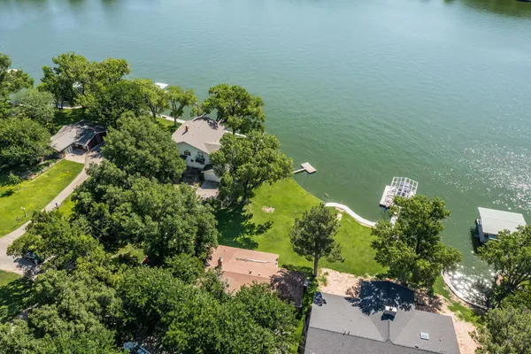 an aerial view of a house with a yard and lake view