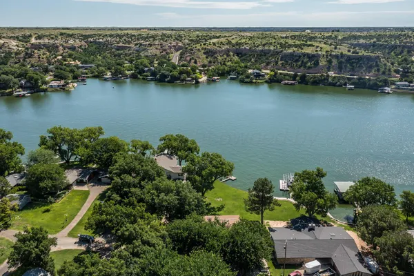 an aerial view of ocean and residential houses with outdoor space