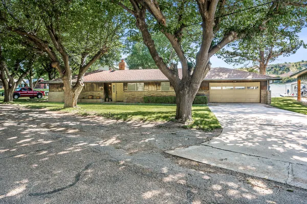 a front view of a house with a yard and trees