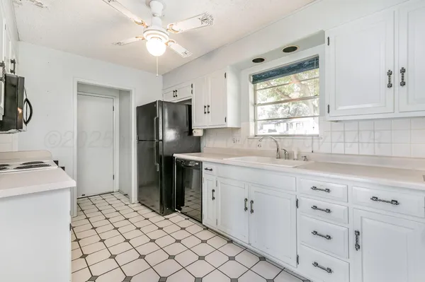 a kitchen with a refrigerator sink and cabinets