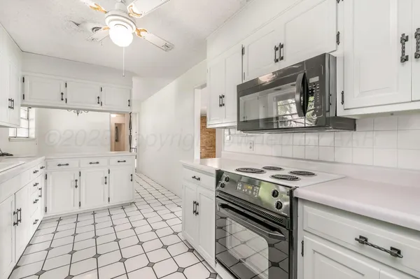 a kitchen with granite countertop a stove a sink and a microwave