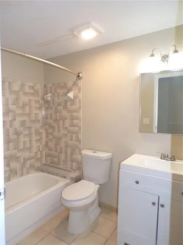 a bathroom with a bathtub shower sink vanity and toilet