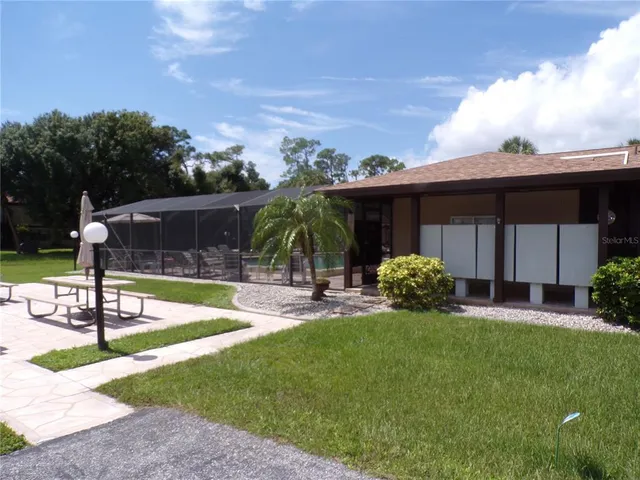 a view of a house with backyard and sitting area