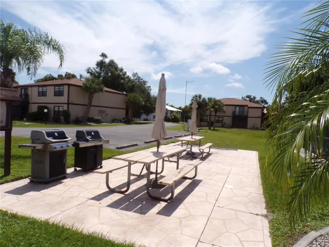 a view of a patio with table and chairs potted plants and palm trees