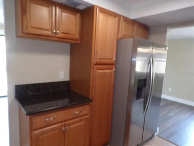 a kitchen with stainless steel appliances granite countertop a refrigerator and a cabinets