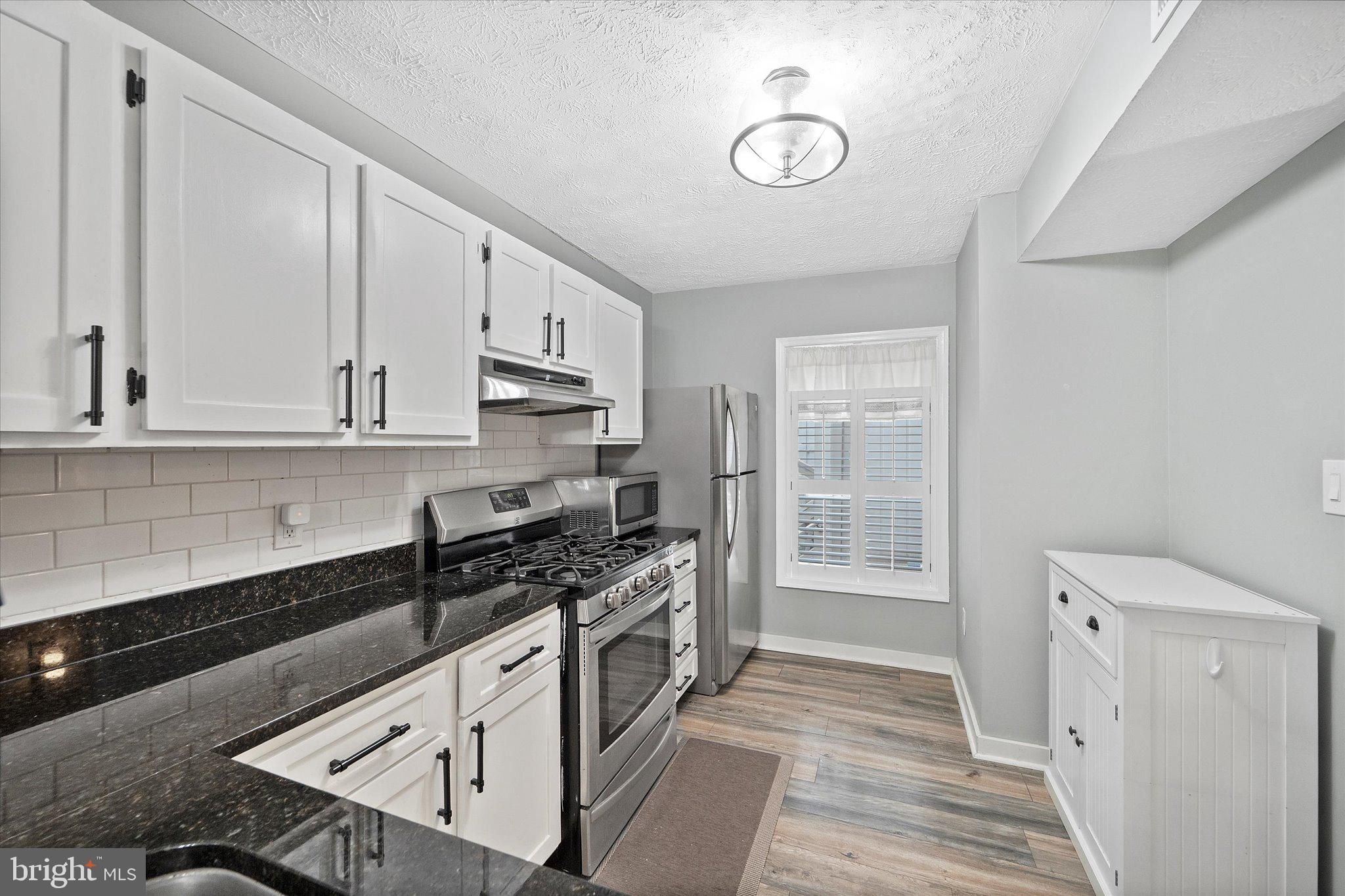 2221 Hunter's Run Drive Reston, VA 20191 - Photo 7 of 25 a kitchen with stainless steel appliances granite countertop a stove and a sink