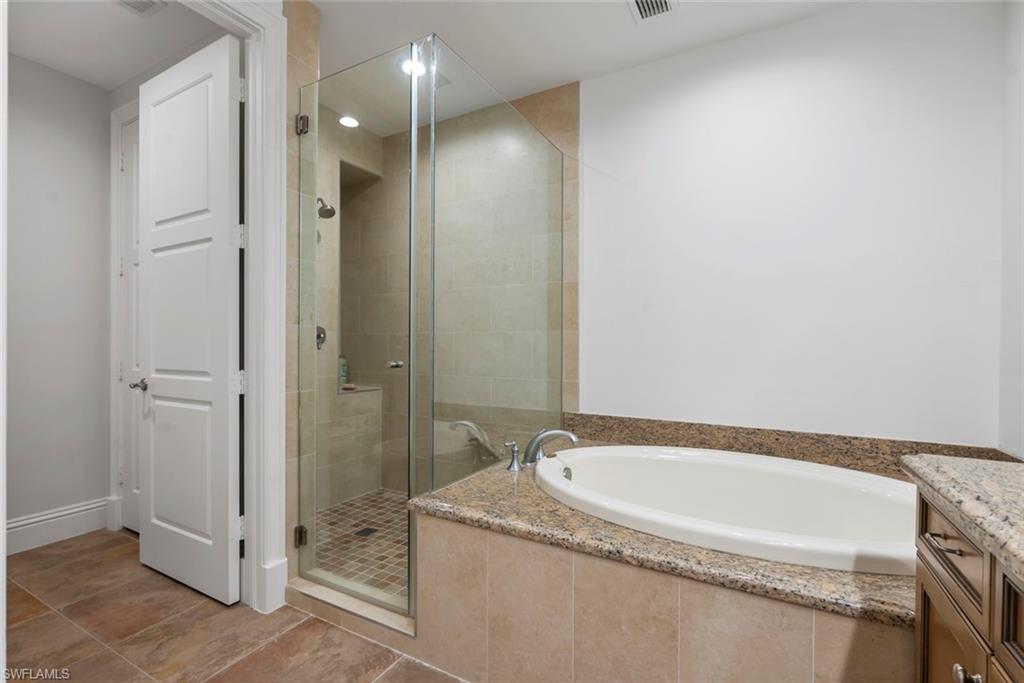 1001 10th Avenue South, Unit C1 Naples, FL 34102 - Photo 12 of 38 a spacious bathroom with a granite countertop tub and a shower