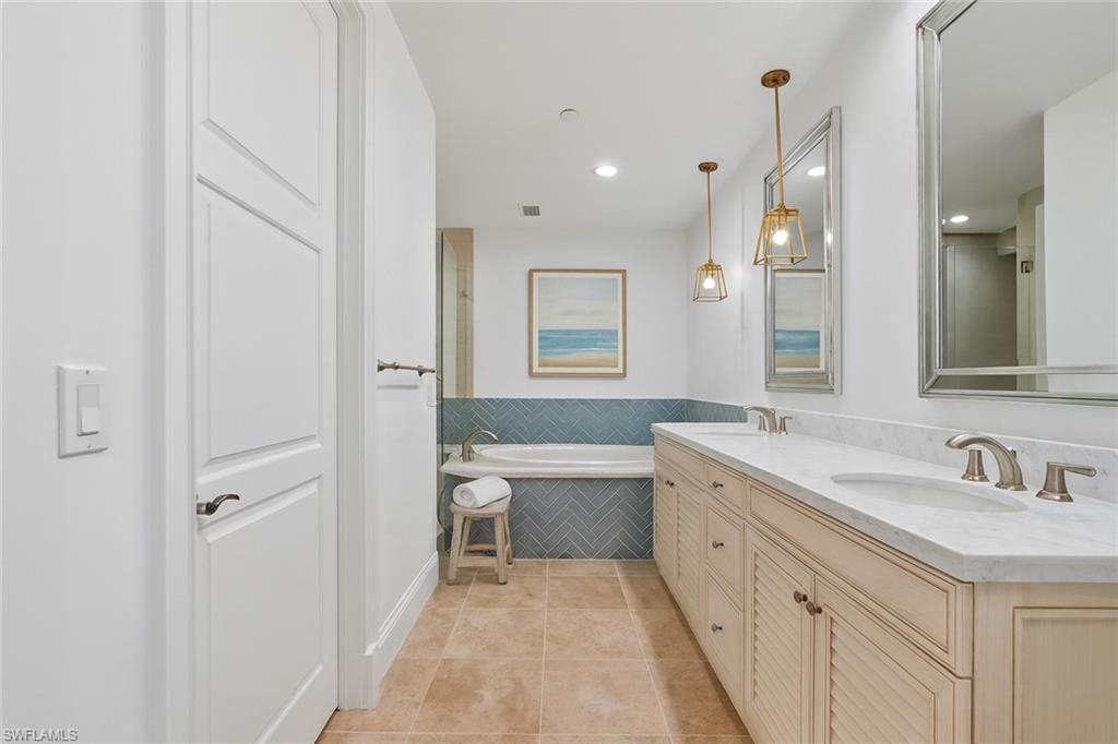1001 10th Avenue South, Unit C1 Naples, FL 34102 - Photo 14 of 38 a spacious bathroom with a double vanity sink toilet mirror and bathtub