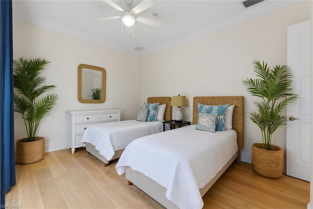 1001 10th Avenue South, Unit C1 Naples, FL 34102 - Photo 18 of 38 a bedroom with two beds and potted plant