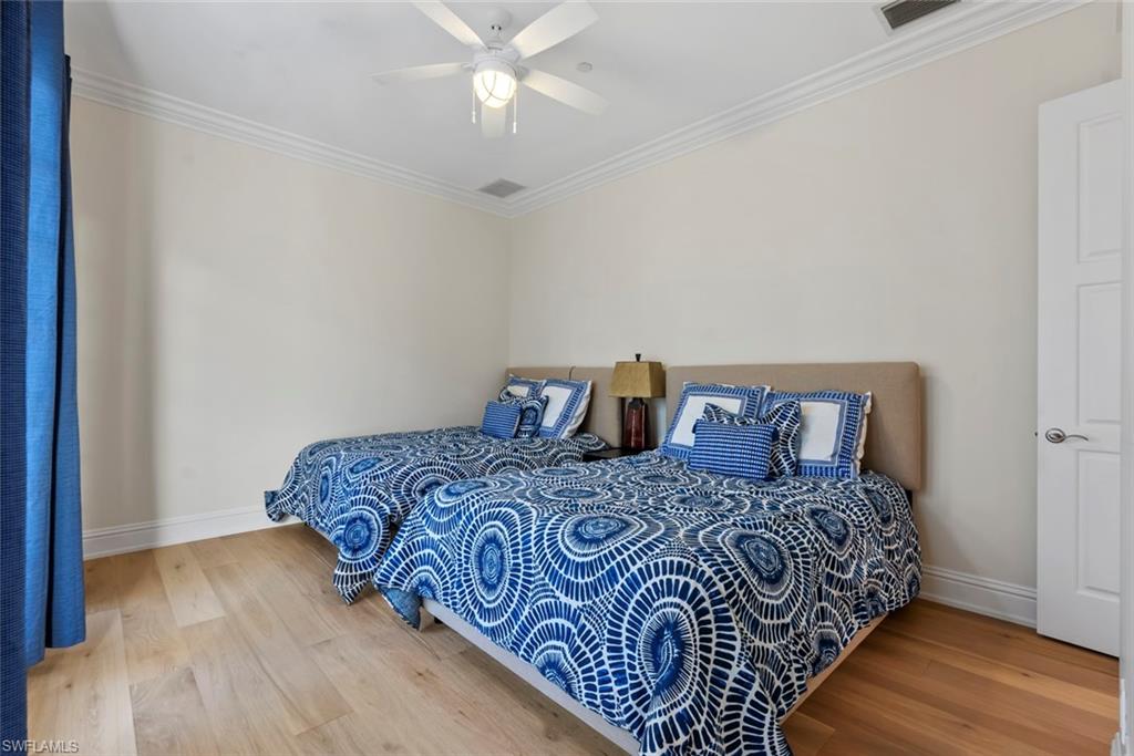 1001 10th Avenue South, Unit C1 Naples, FL 34102 - Photo 19 of 38 a bedroom with a bed and a chandelier