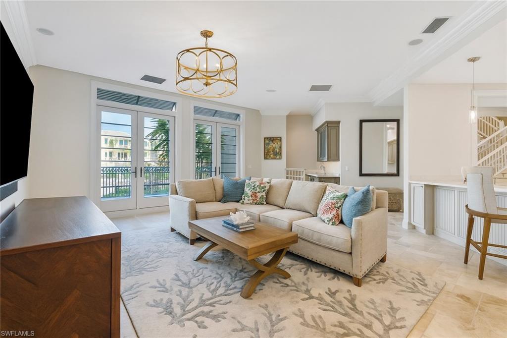 1001 10th Avenue South, Unit C1 Naples, FL 34102 - Photo 5 of 38 a living room with furniture a rug and a chandelier