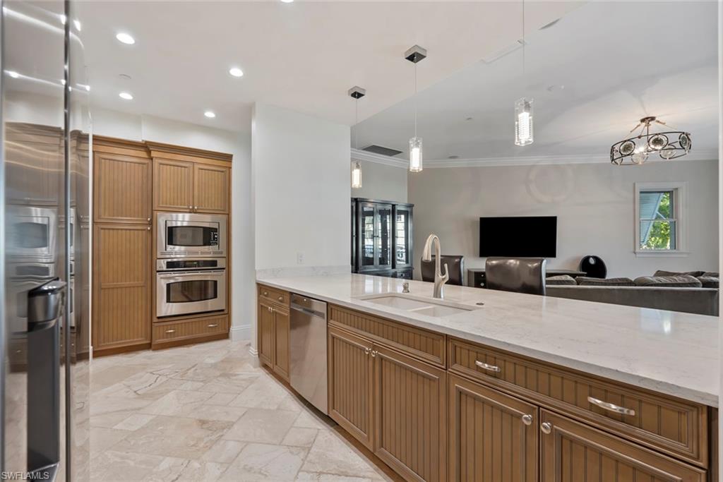 1001 10th Avenue South, Unit C1 Naples, FL 34102 - Photo 38 of 38 a large kitchen with a large counter top a sink and stainless steel appliances