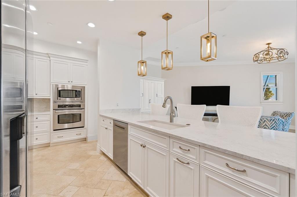 1001 10th Avenue South, Unit C1 Naples, FL 34102 - Photo 7 of 38 a kitchen with stainless steel appliances kitchen island granite countertop a sink and a refrigerator
