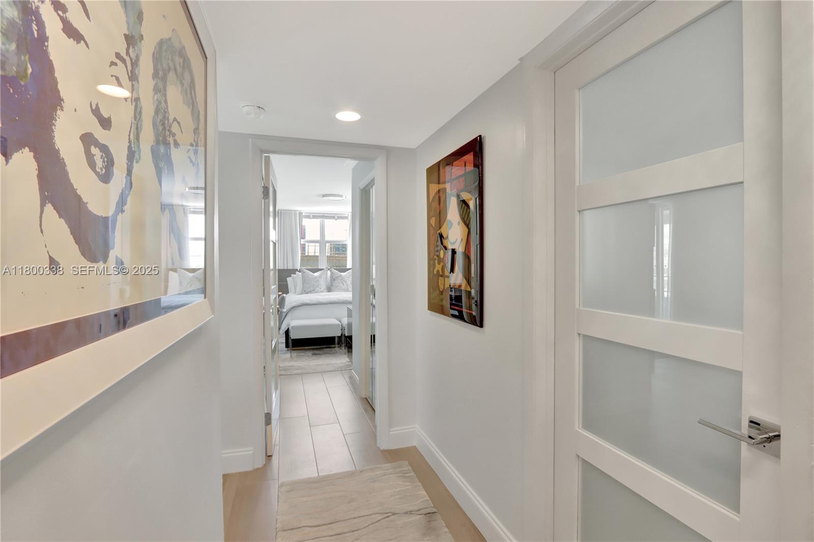 720 Collins Avenue, Unit PH1 Miami Beach, FL 33139 - Photo 12 of 27 a view of a hallway with wooden floor and a bathroom