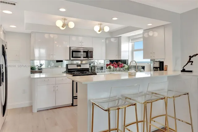 a kitchen with kitchen island granite countertop white cabinets and stainless steel appliances