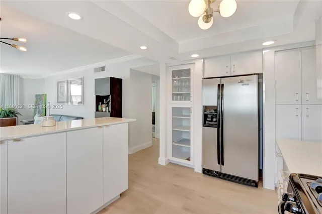 a kitchen with kitchen island a counter top space stainless steel appliances and cabinets