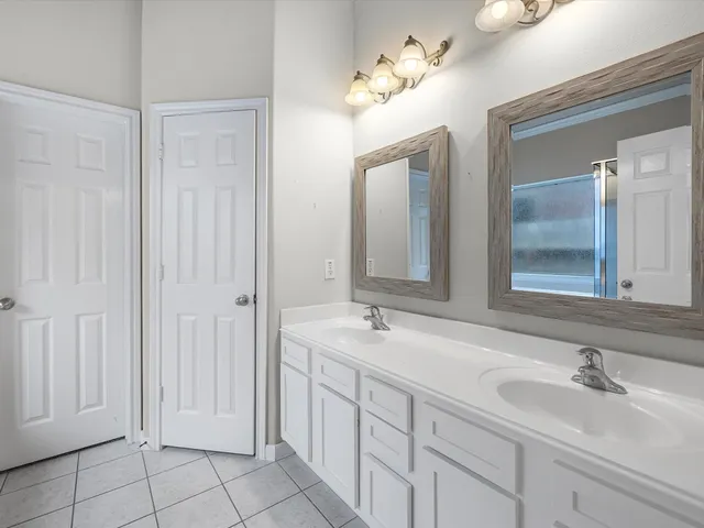 a bathroom with a double vanity sink and a mirror
