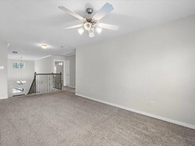 an empty room with fan and windows