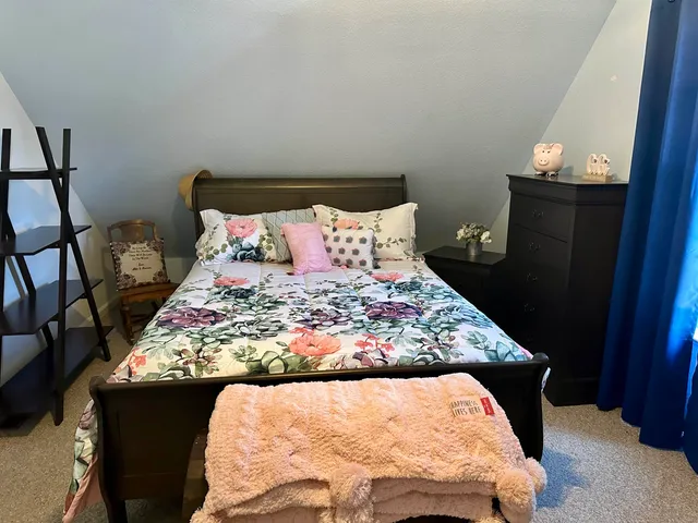 a bed sitting in a bedroom next to a window