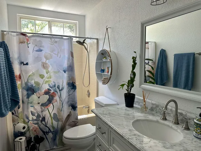 a bathroom with a granite countertop toilet sink and mirror