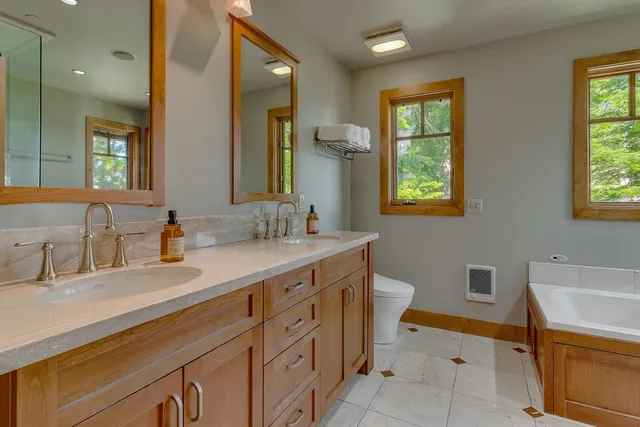 a bathroom with a granite countertop sink mirror and a toilet