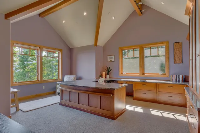 a bathroom with a granite countertop tub sink and large window