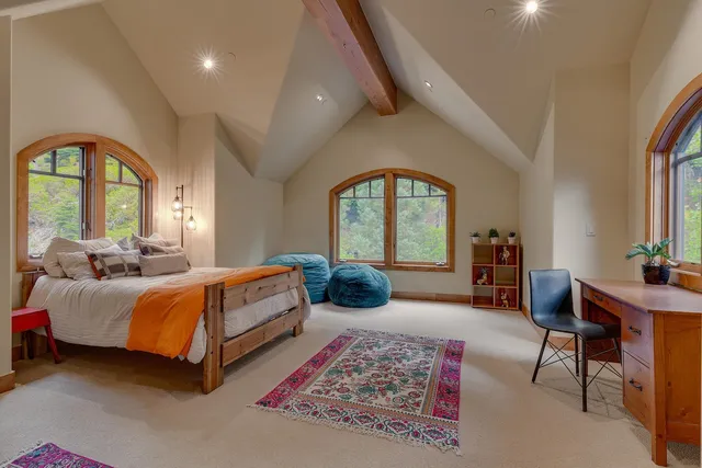 a living room with furniture a rug potted plant and a large window