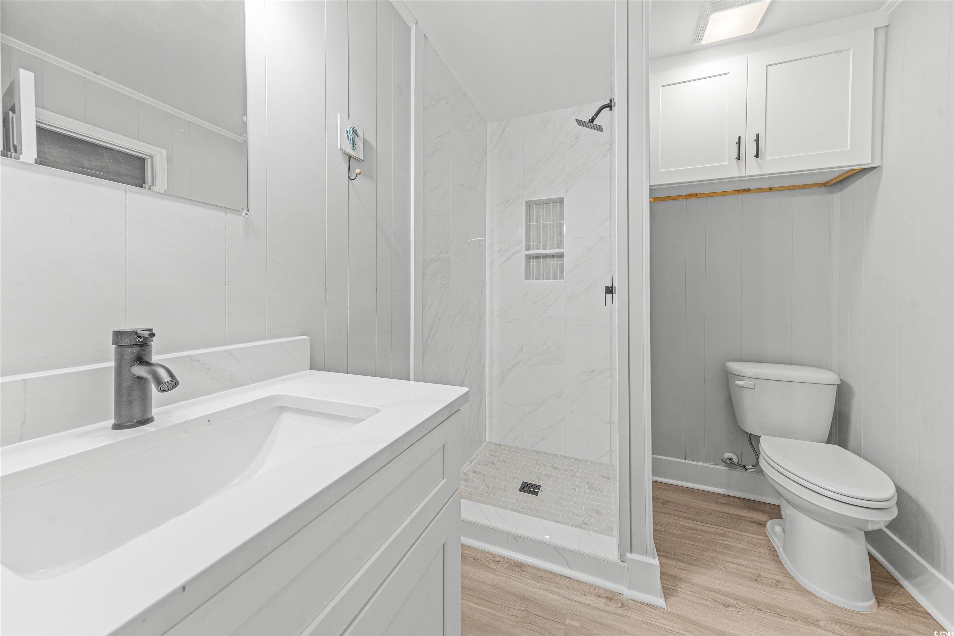 338 State Rd S-26-530 Murrells Inlet, SC 29576 - Photo 6 of 39 Full bath featuring baseboards, toilet, wood finished floors, vanity, and a stall shower