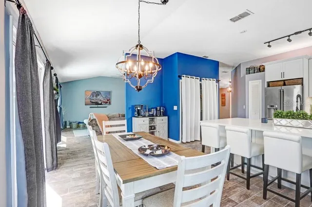 a view of a dining room with furniture a chandelier and wooden floor