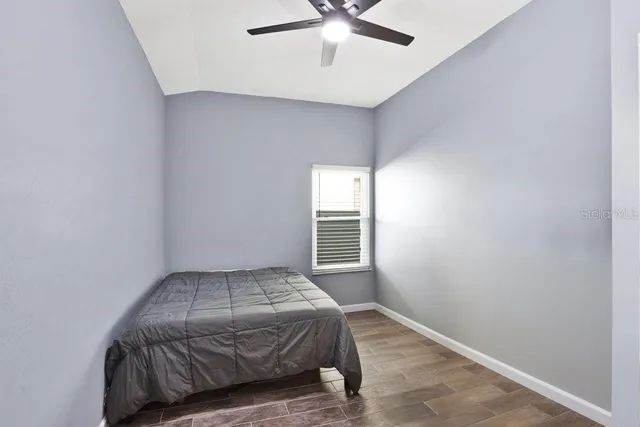 a bedroom with a bed and a ceiling fan