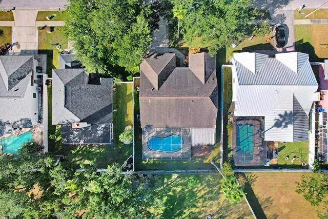 an aerial view of residential houses with outdoor space and trees