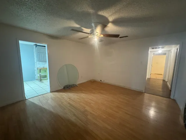 a view of empty room with wooden floor