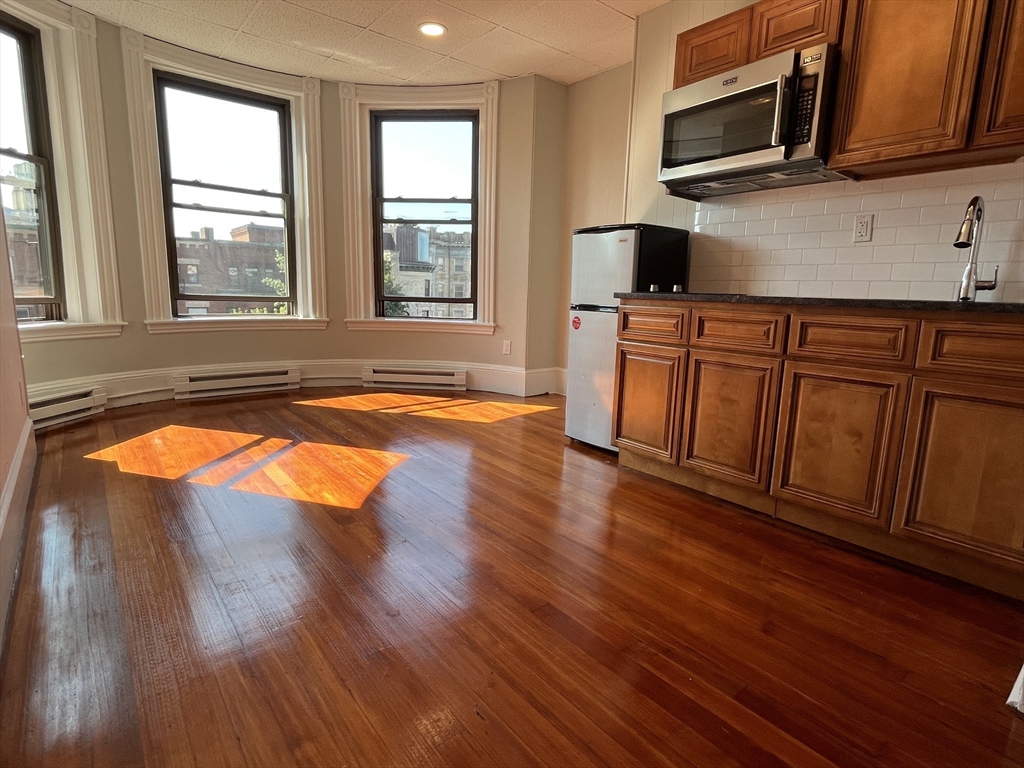 868 Beacon Street, Unit 15 Boston, MA 02215 - Photo 2 of 5 a kitchen with wooden floors and wooden cabinets