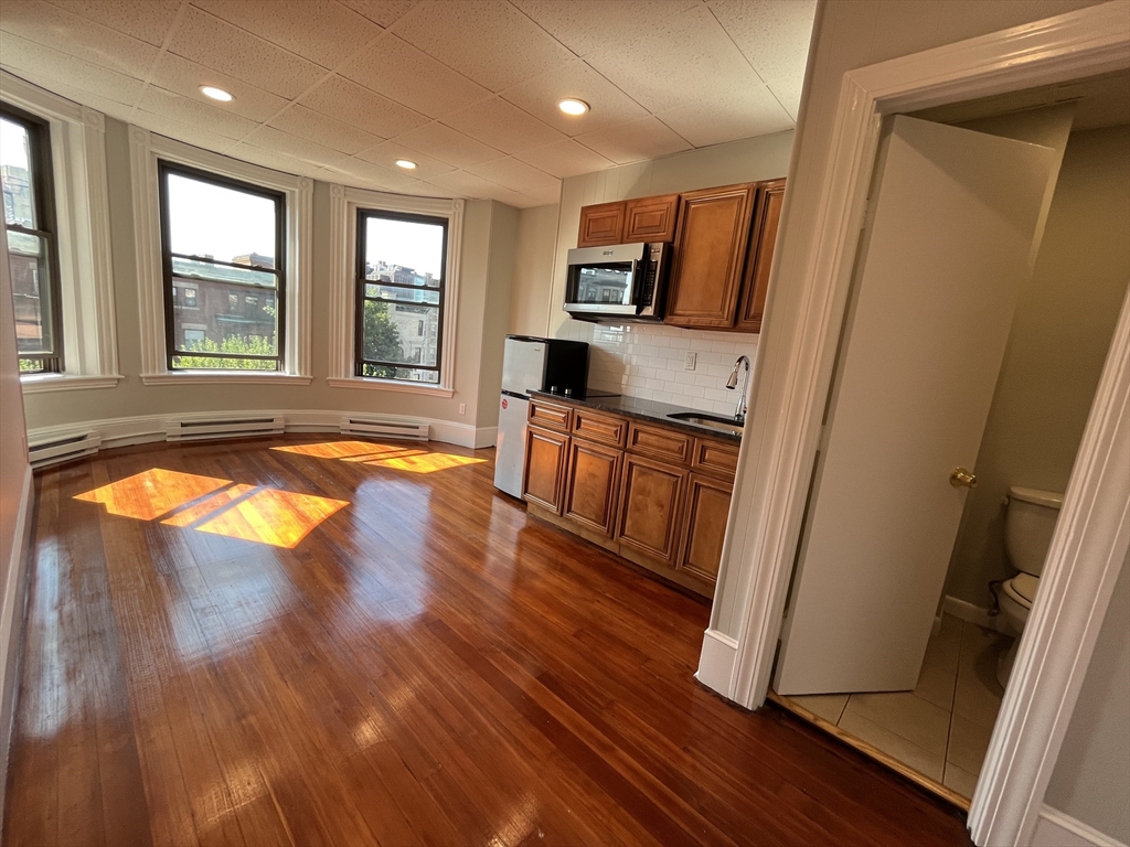 868 Beacon Street, Unit 15 Boston, MA 02215 - Photo 5 of 5 a view of a kitchen with wooden floor and staircase