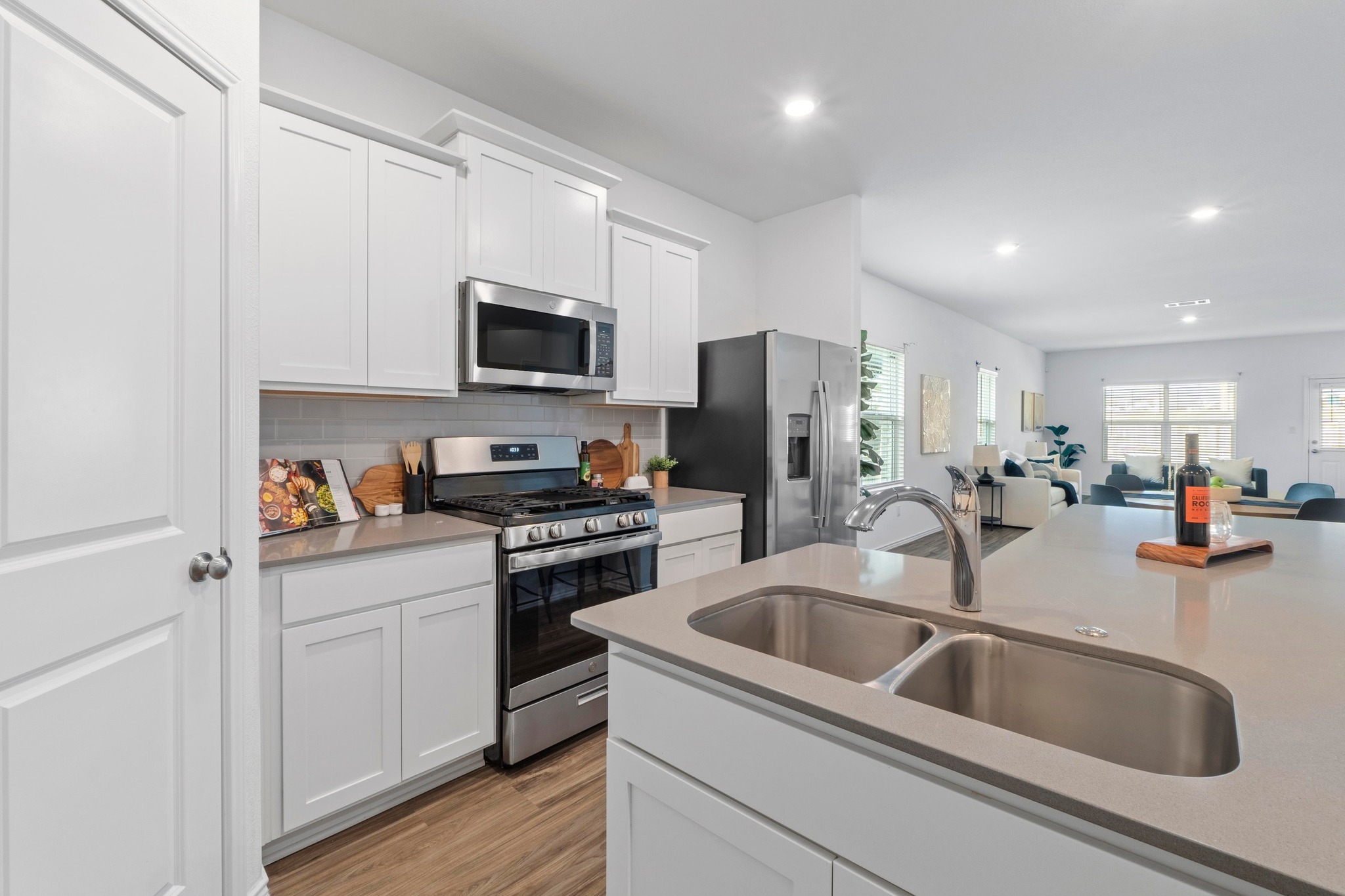1705 Woolsey Way Leander, TX 78641 - Photo 15 of 35 a kitchen with stainless steel appliances granite countertop a sink a stove and a refrigerator
