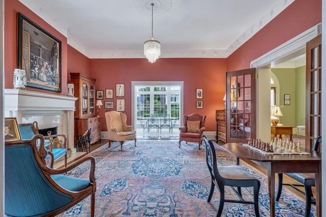 a living room with furniture a fireplace and large windows