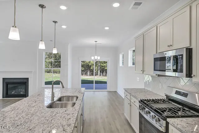 a kitchen with granite countertop a stove and a sink