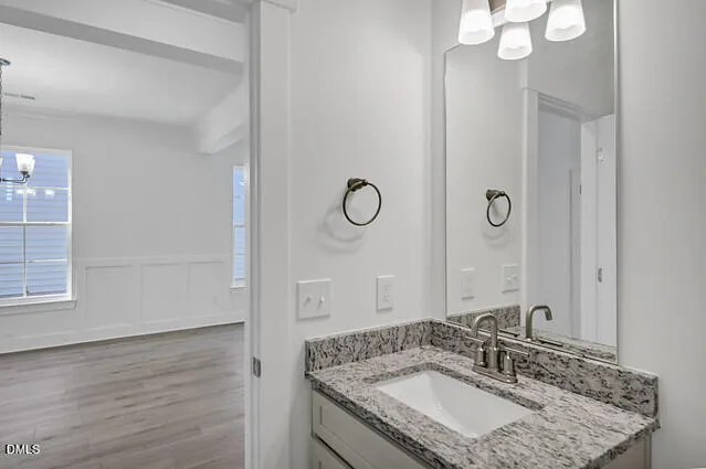 a bathroom with a granite countertop sink a mirror and shower