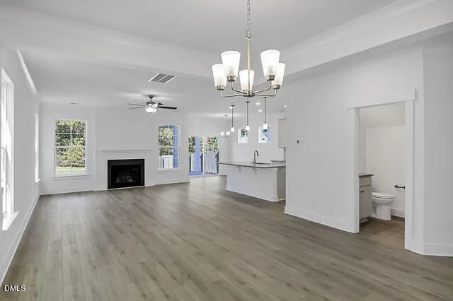 a view of a livingroom with a fireplace a chandelier and wooden floor