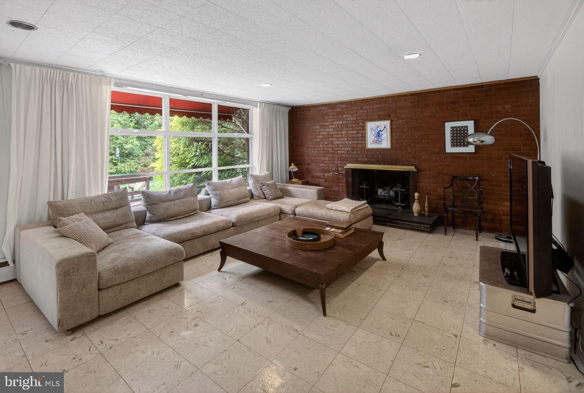 5804 Plainview Road Bethesda, MD 20817 - Photo 24 of 34 a living room with furniture a fireplace and a table