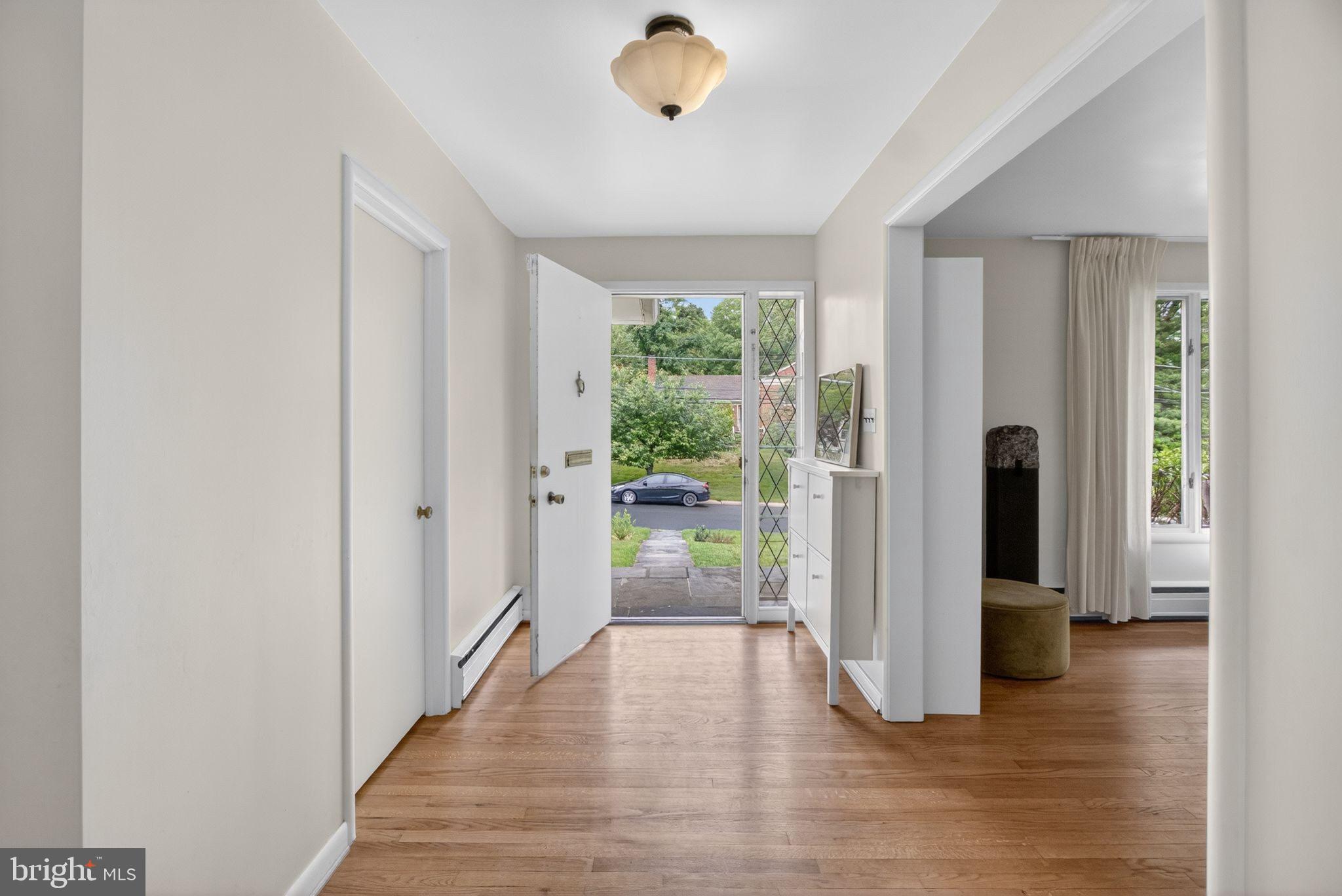 5804 Plainview Road Bethesda, MD 20817 - Photo 3 of 34 a view of a hallway with wooden floor and a livingroom
