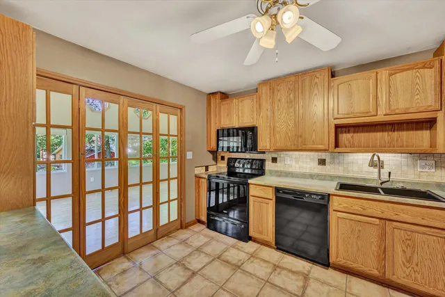 a kitchen with stainless steel appliances granite countertop a stove top oven a sink dishwasher a dining table and chairs with wooden floor