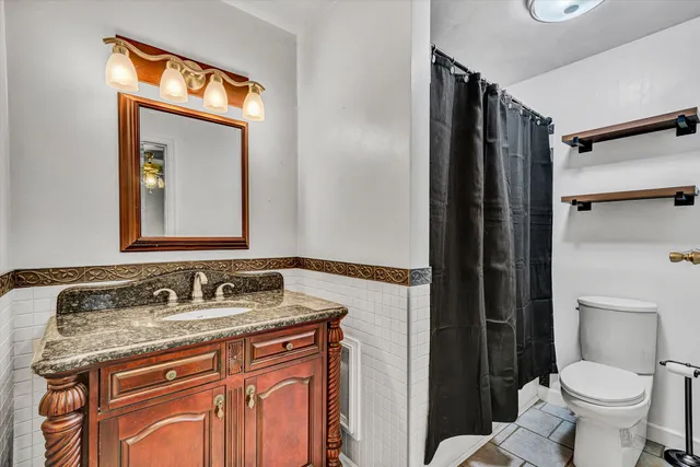 a bathroom with a granite countertop sink toilet and shower