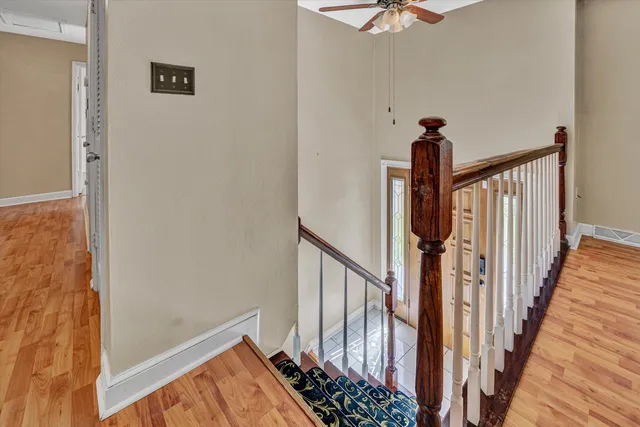 a view of a hallway with wooden floor and staircase