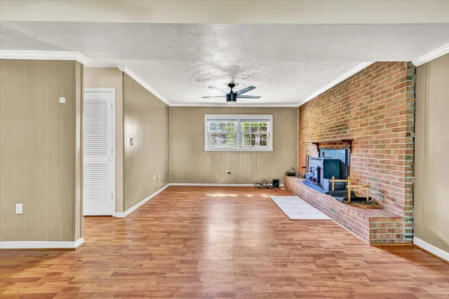a view of an empty room with a fireplace and a window