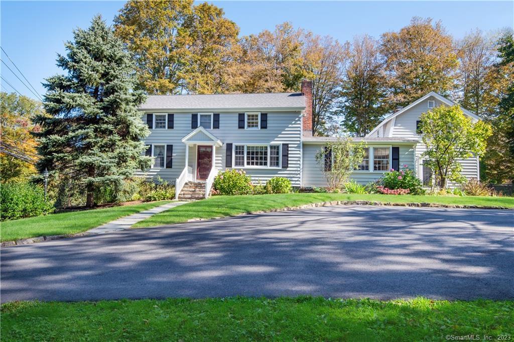 a front view of a house with a garden and trees