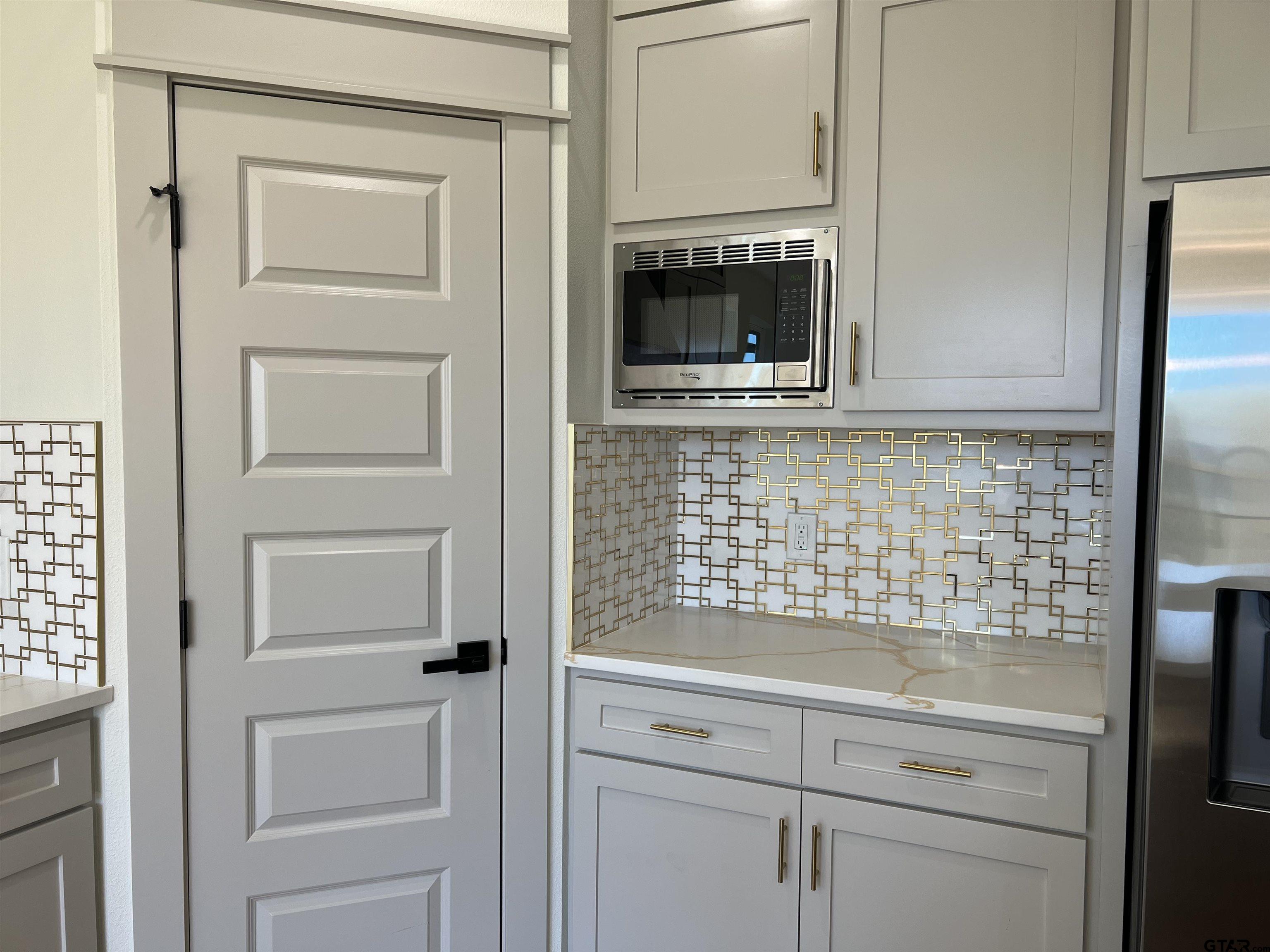 242 Sides Bullard, TX 75757 - Photo 10 of 41 a kitchen with white cabinets and a fireplace