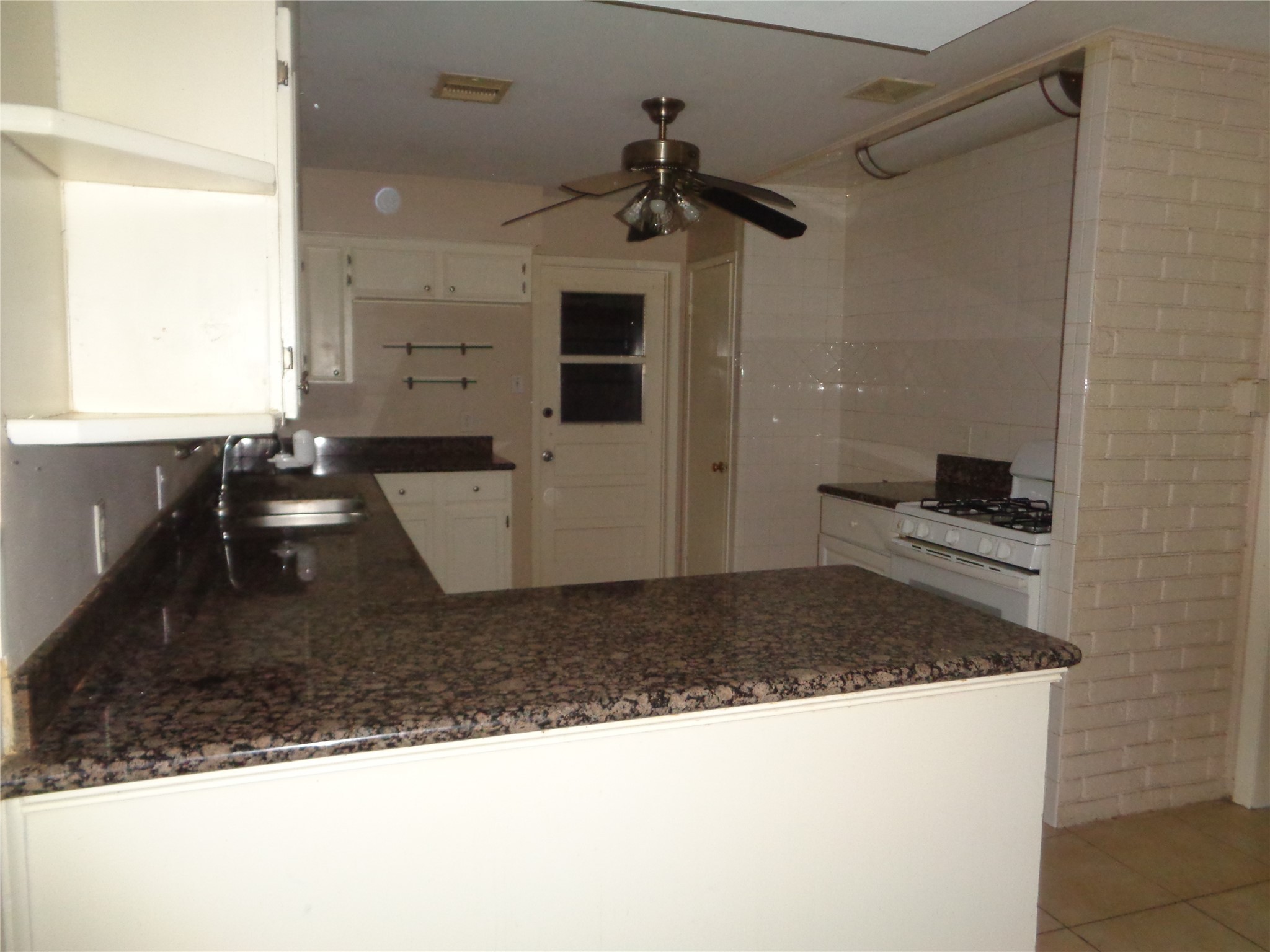 11215 Mayfield Road Houston, TX 77043 - Photo 6 of 16 a kitchen with a faucet a stove and a microwave