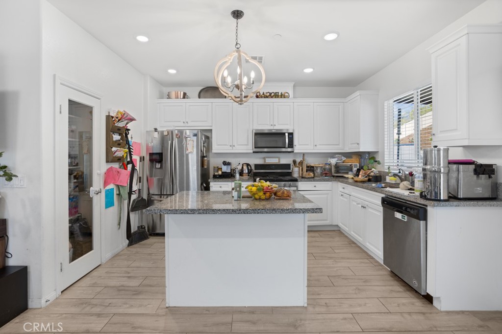 20920 Spring Street Riverside, CA 92507 - Photo 11 of 30 a kitchen with stainless steel appliances granite countertop a refrigerator a stove top oven a sink dishwasher and white cabinets