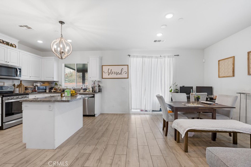 20920 Spring Street Riverside, CA 92507 - Photo 8 of 30 a kitchen with a table chairs microwave and cabinets